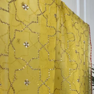 Detail of yellow bridal sharara set showing gota embroidered cuffs, gold brocade sharara skirt and sequin dupatta Pakistani bridal suit