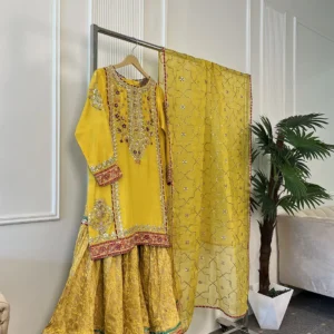 Pakistani bridal kurti with heavy zardozi floral embroidery, gota patti border and round neckline — yellow mehndi dress close-up