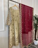 Full view of 3-piece gold and maroon Pakistani bridal suit on clothing rack showing embroidered kurti, heavy sleeve embroidery and maroon dupatta with gold border
