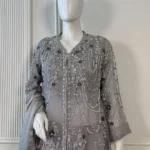 Grey organza Pakistani bridal suit on mannequin with silver zardozi embroidery, pearl bead chain drape and 3D navy floral appliqué front upper body view
