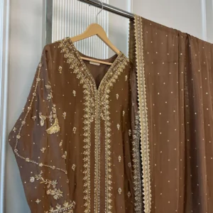 Side view of brown 3-piece Pakistani bridal suit with gold embroidery and matching pearl dot dupatta on display rack