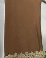 Side view of brown 3-piece Pakistani bridal suit with gold embroidery and matching pearl dot dupatta on display rack